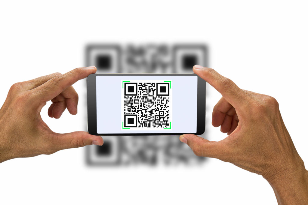 Hands holding smartphone scanning QR code on white background, business concept